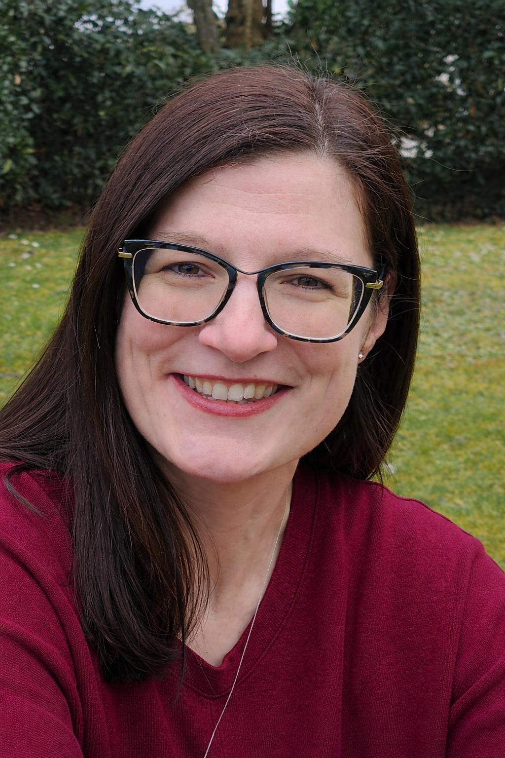 lächelnde frau im burgunderfarbenen pullover